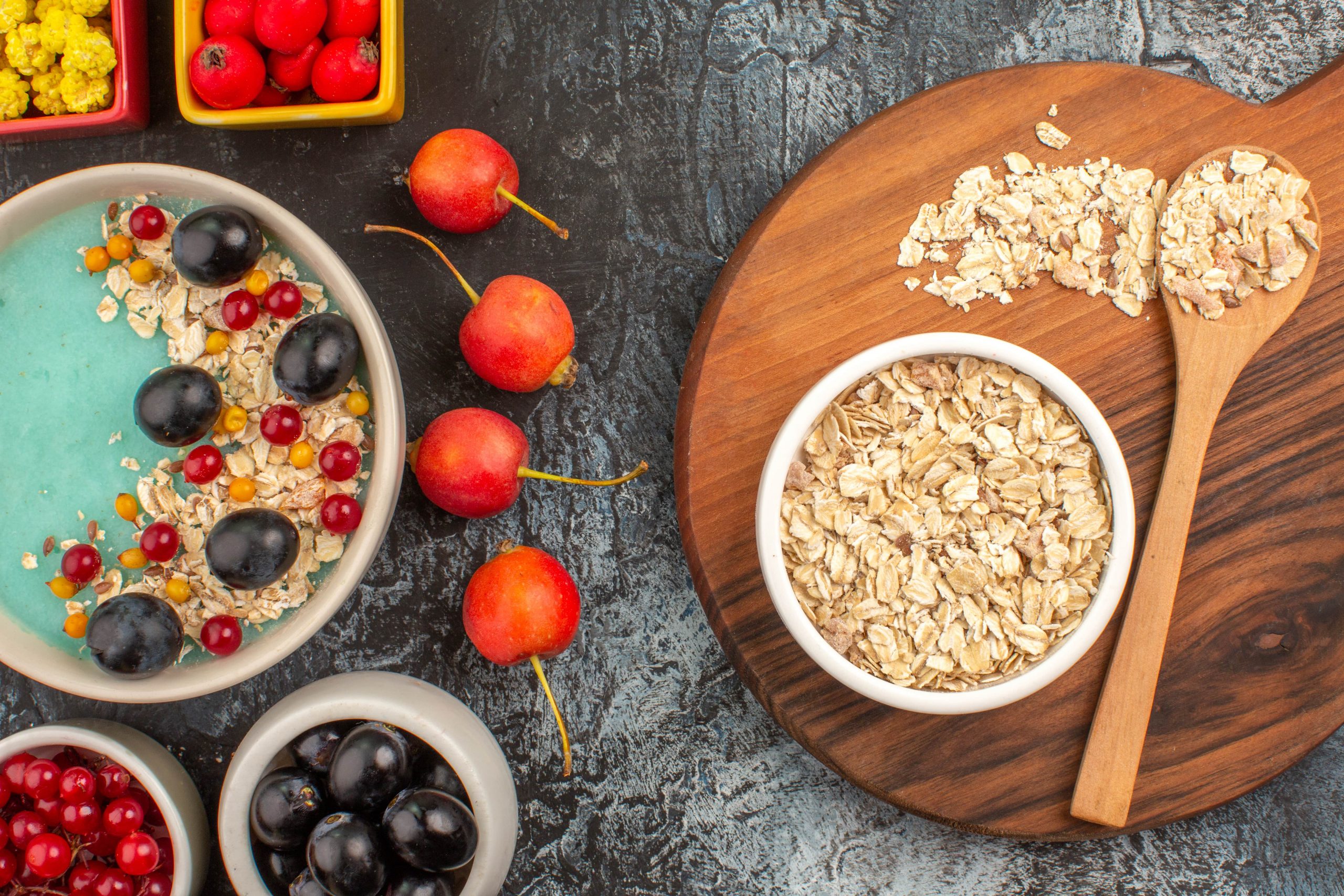Haferflocken, Beeren und eine fruchtige Frühstücksbowl auf einem Holztisch